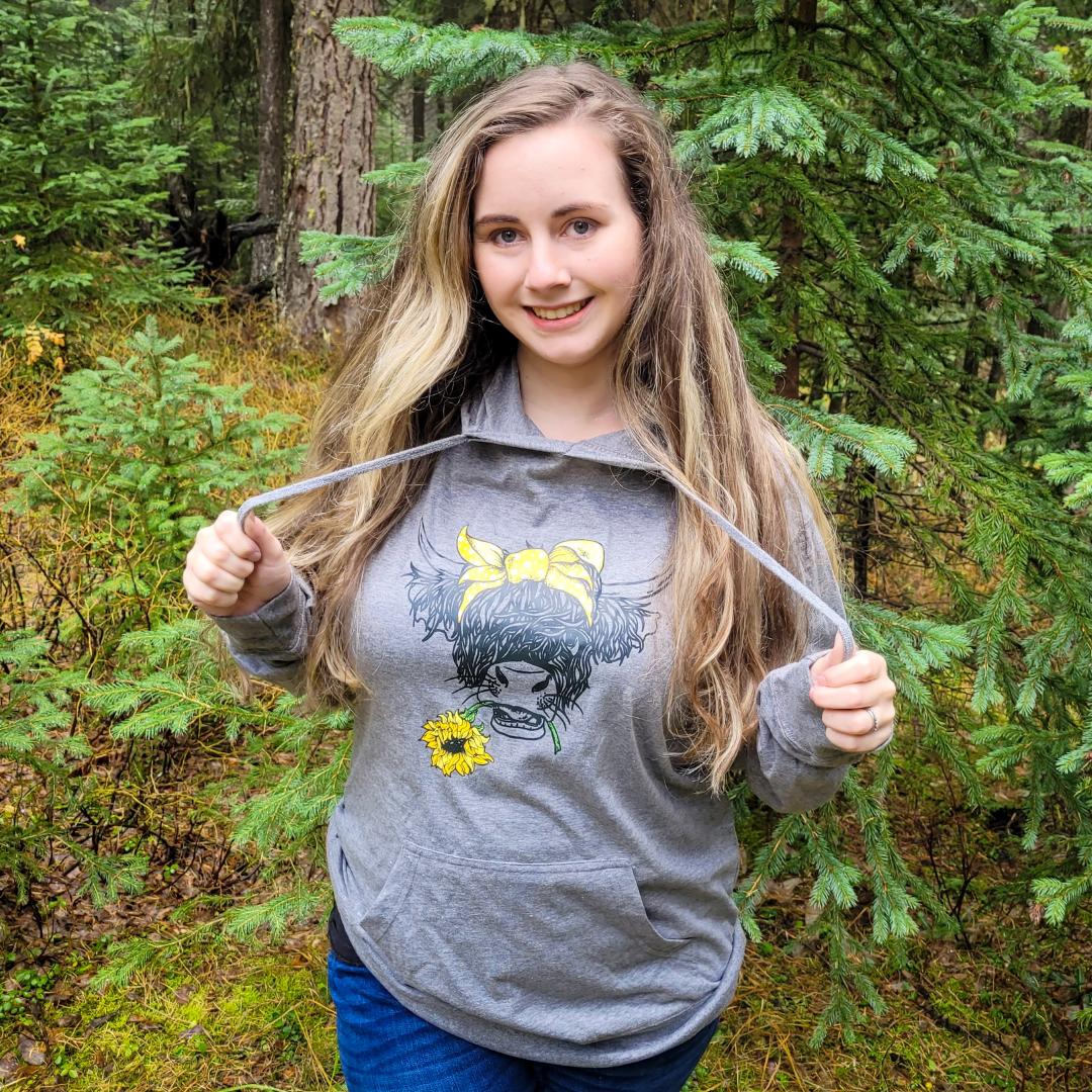 Women in grey hoodie with a highland cow on it