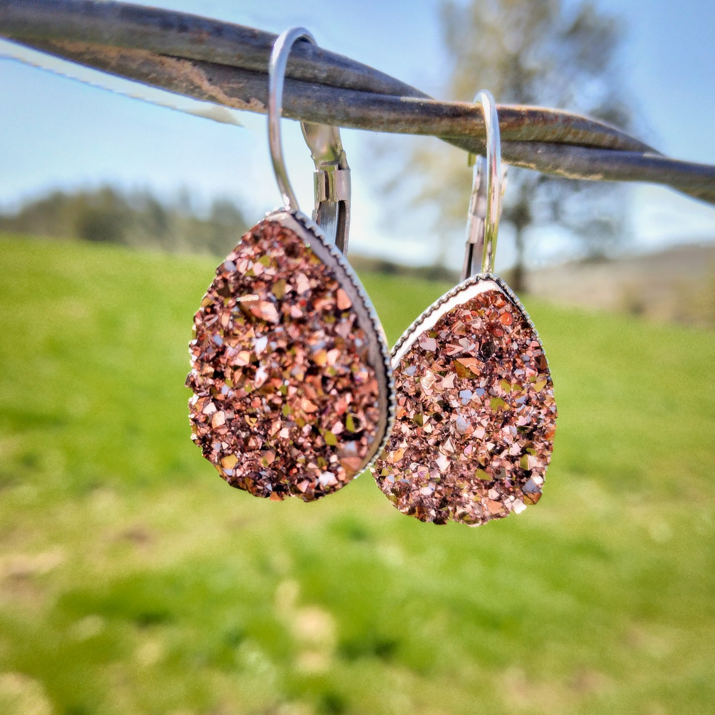 Rose teardrop dangles displayed on a wire outside.